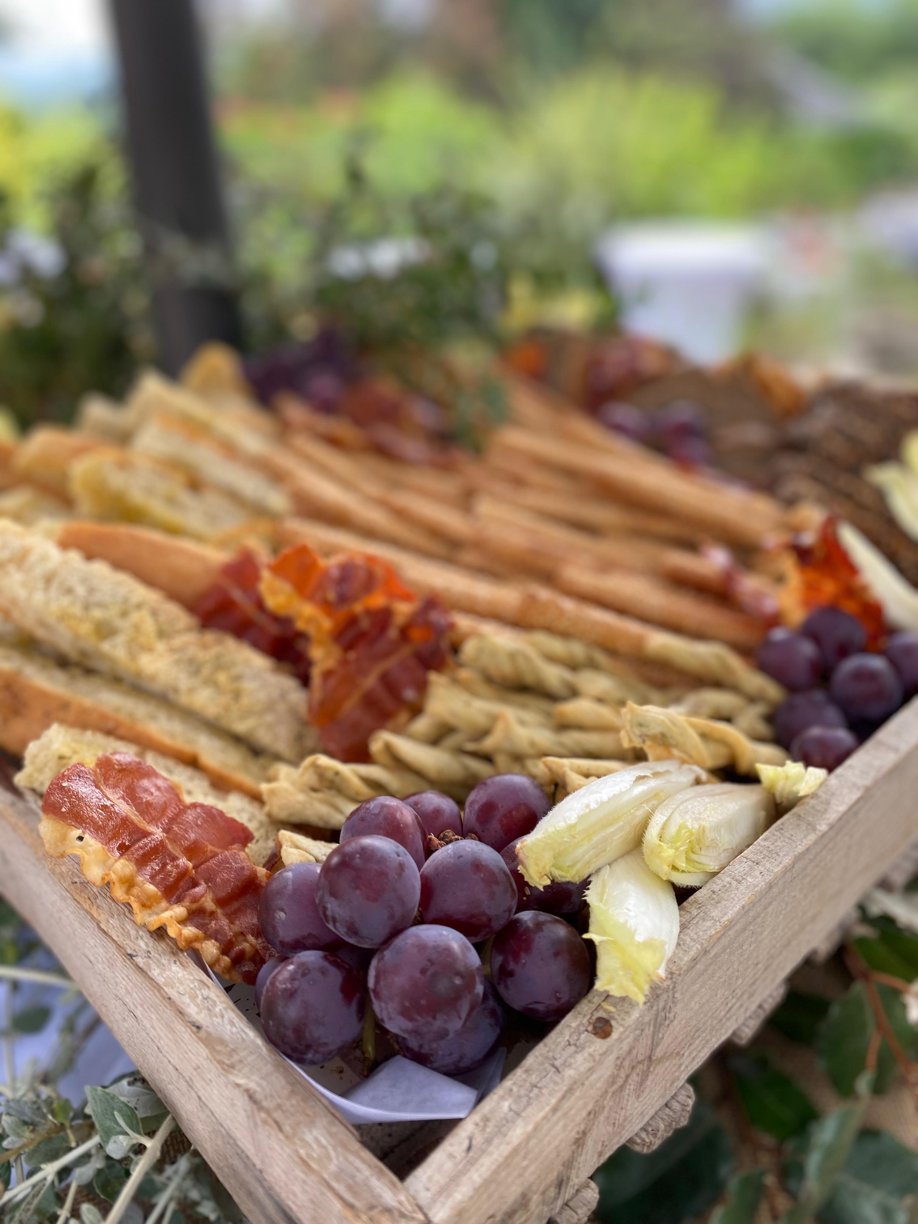 Planche apéritive avec raisins, charcuterie et gressins